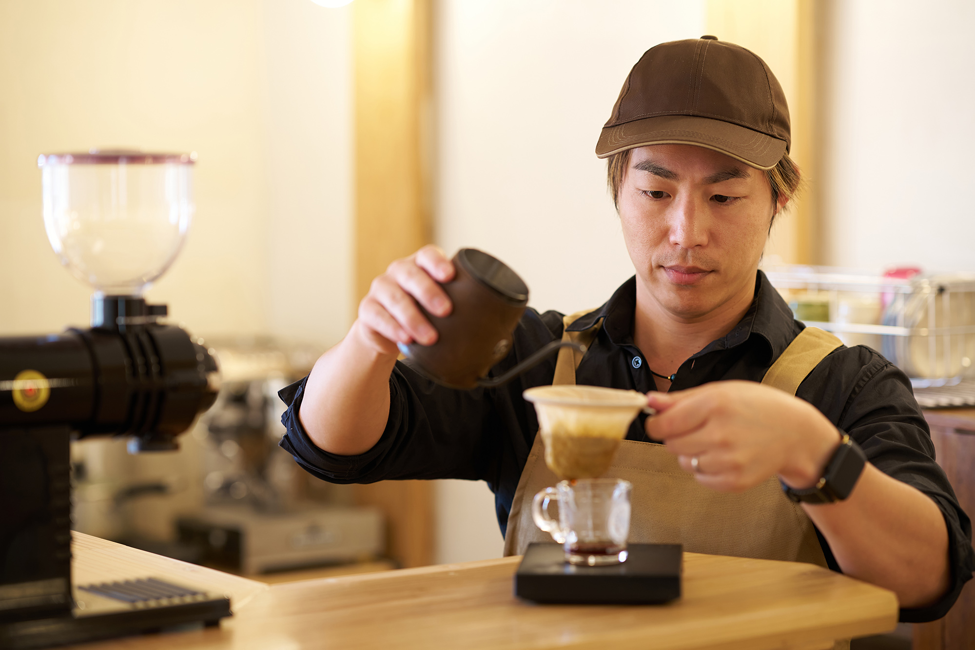 カフェでコーヒーを淹れる人物と仕事の様子