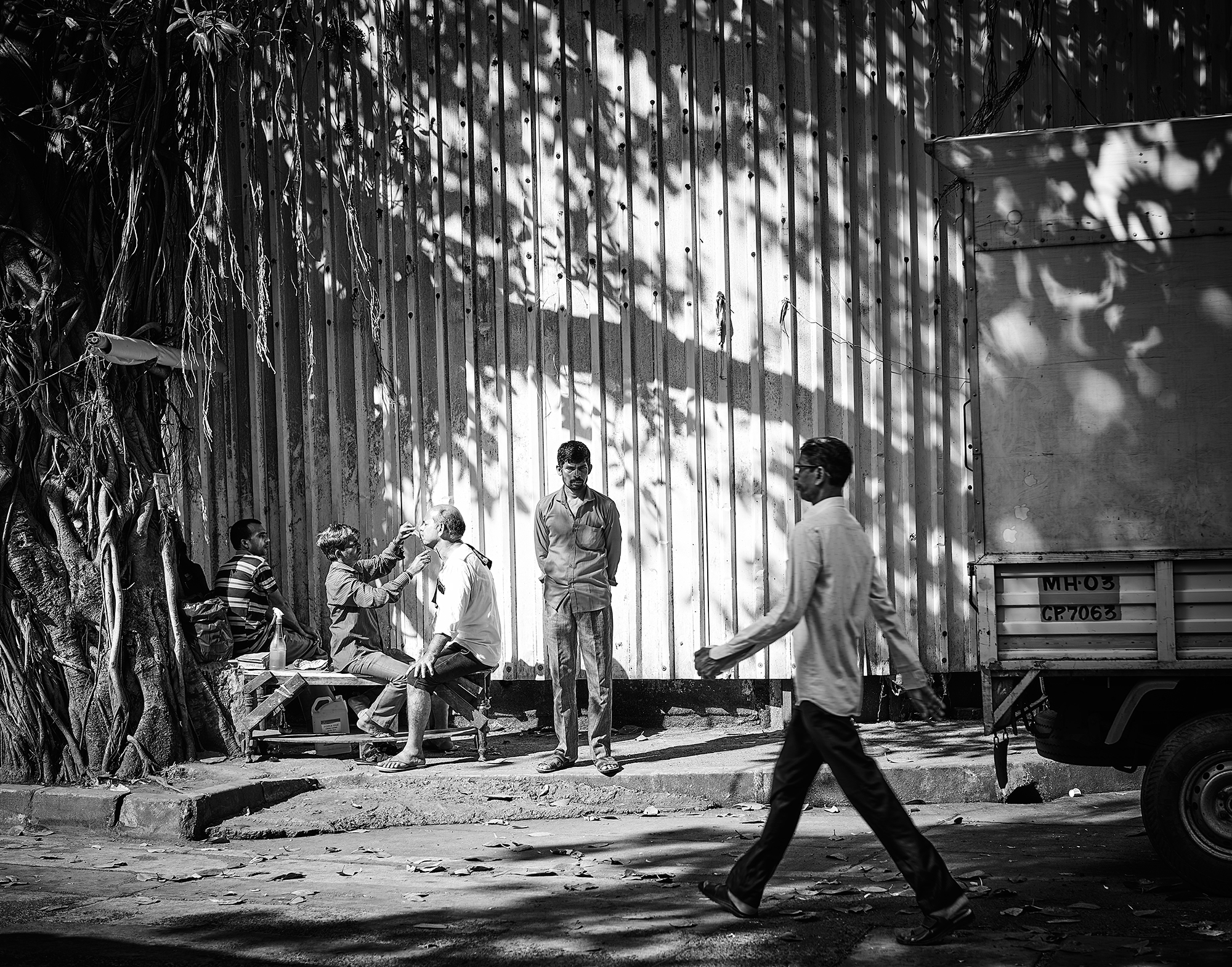 ムンバイの路上で人々が過ごすモノクロ写真